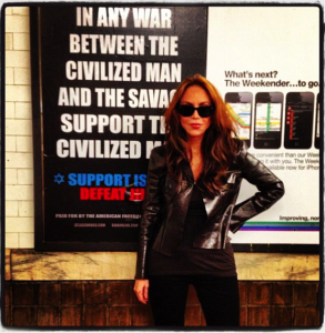 Geller standing in front of one of her posters. Credit: Facebook